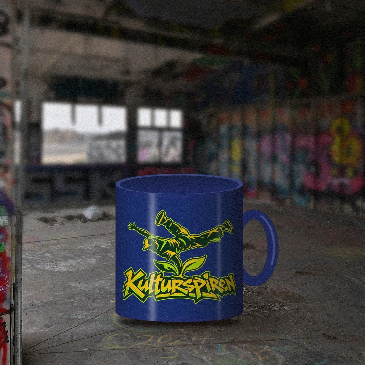 Blå Kulturspiren-kopp på betonggulv i et graffitilokale